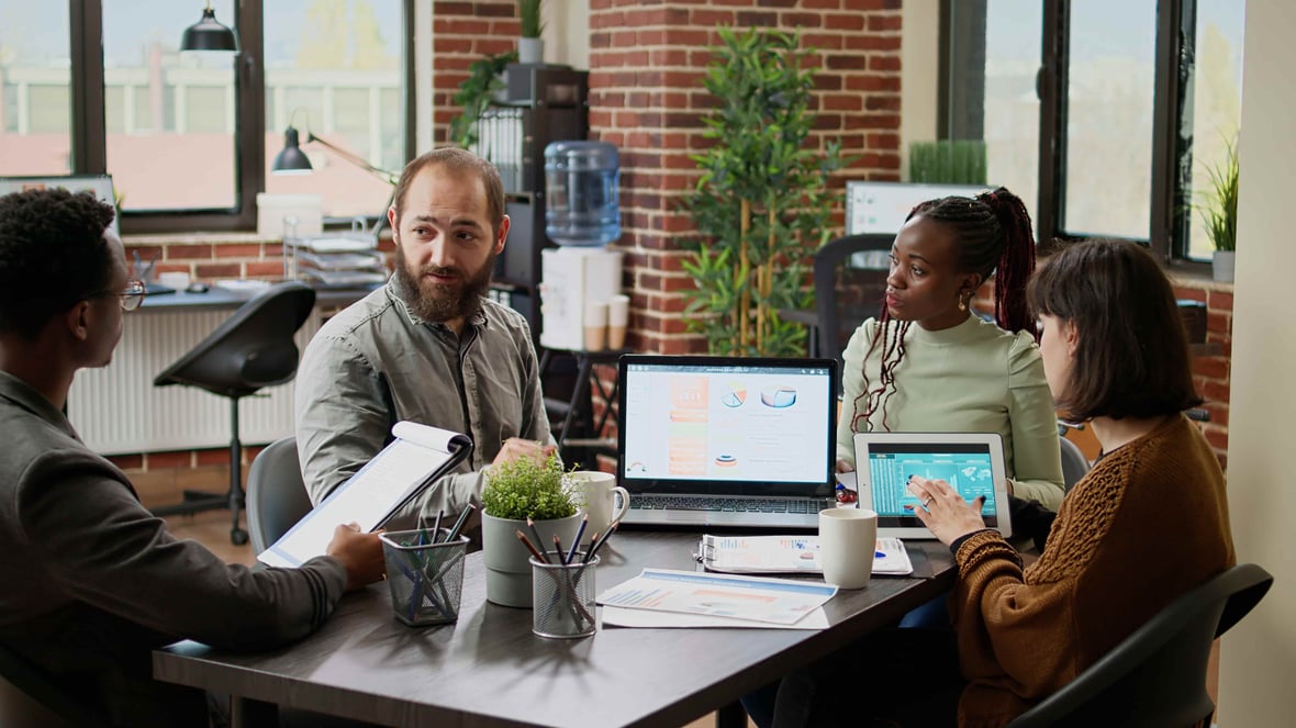 A group of coworkers discuss their marketing plans for the ZoomInfo Enrich integration with HubSpot.