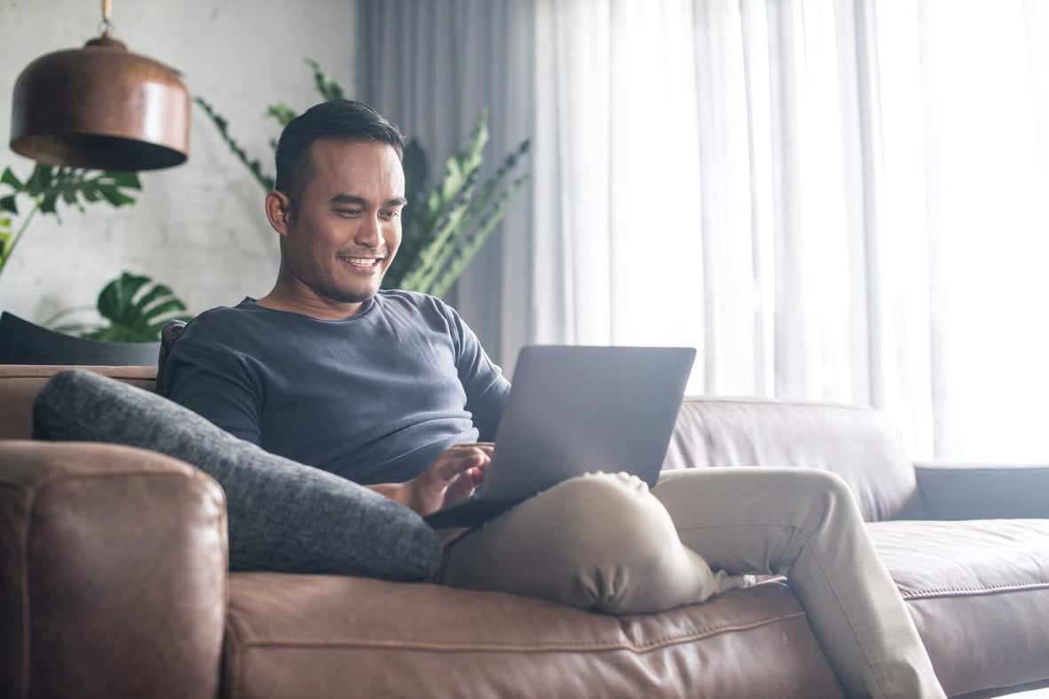 Man looking at a computer in his couch