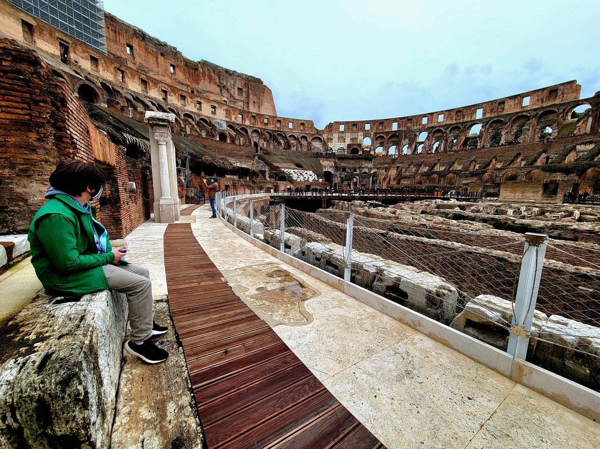A teenager sits in the Colosseum in Rome