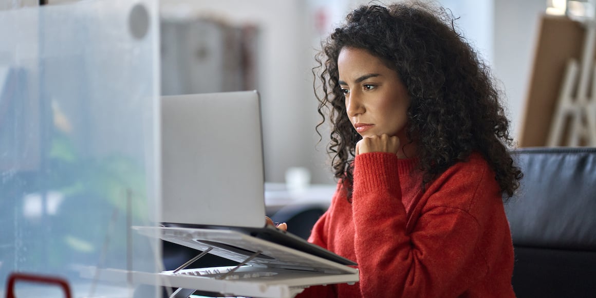 Digital Marketing Professional Reading An Article About Creating Buyer Personas That Drive Results on her laptop raised on an ergonomic stand