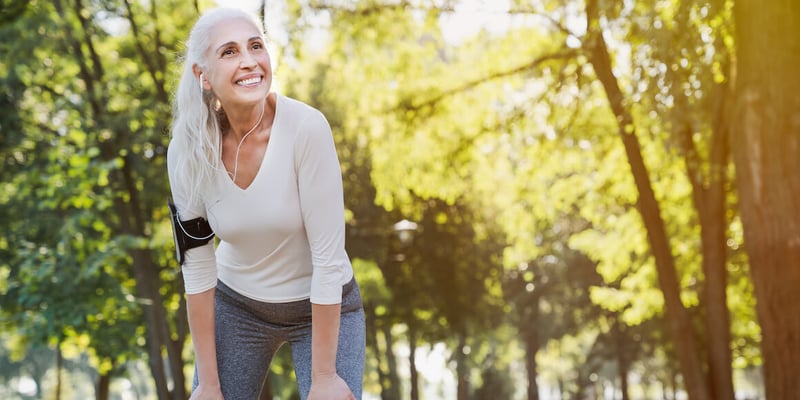 senior woman pausing from outdoor exercise and smiling