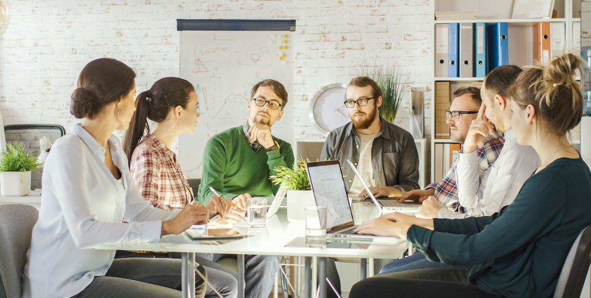 Professionals around a community working space having a charismatic discussion