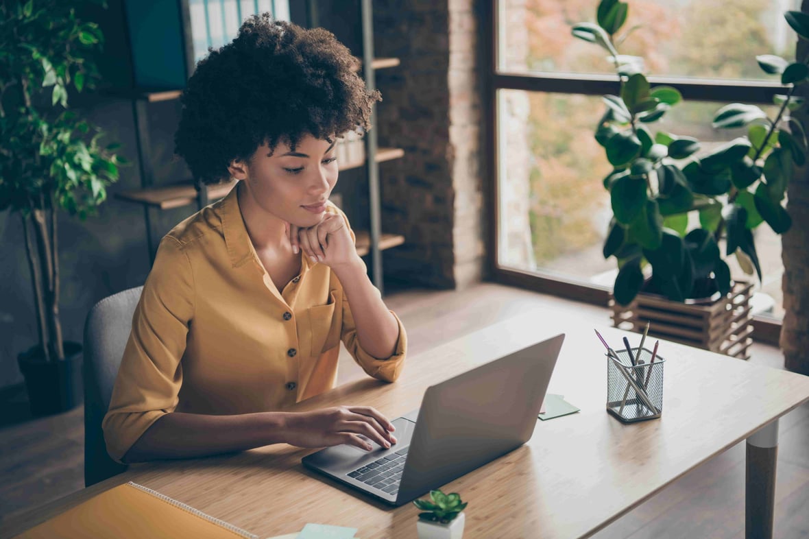 woman sitting in a desk looking at her computer