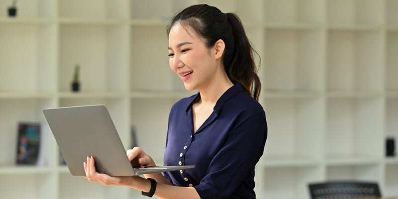 Woman holding a laptop smiling