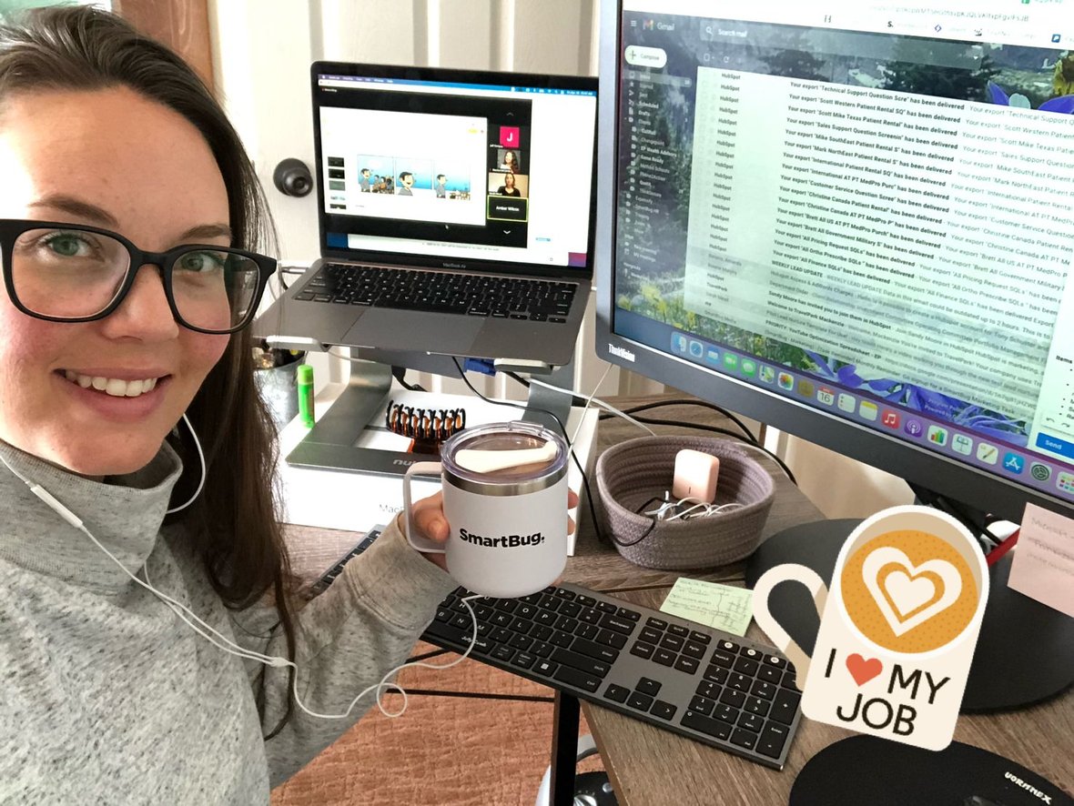 A SmartBug marketer holding a SmartBug mug and posing in front of her work desk at HubSpot certification day