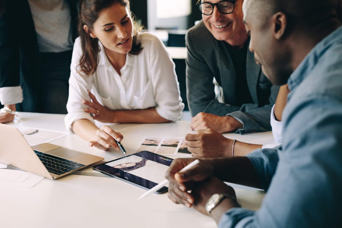 Businesswoman explains HubSpot Beta Programs to marketers at table