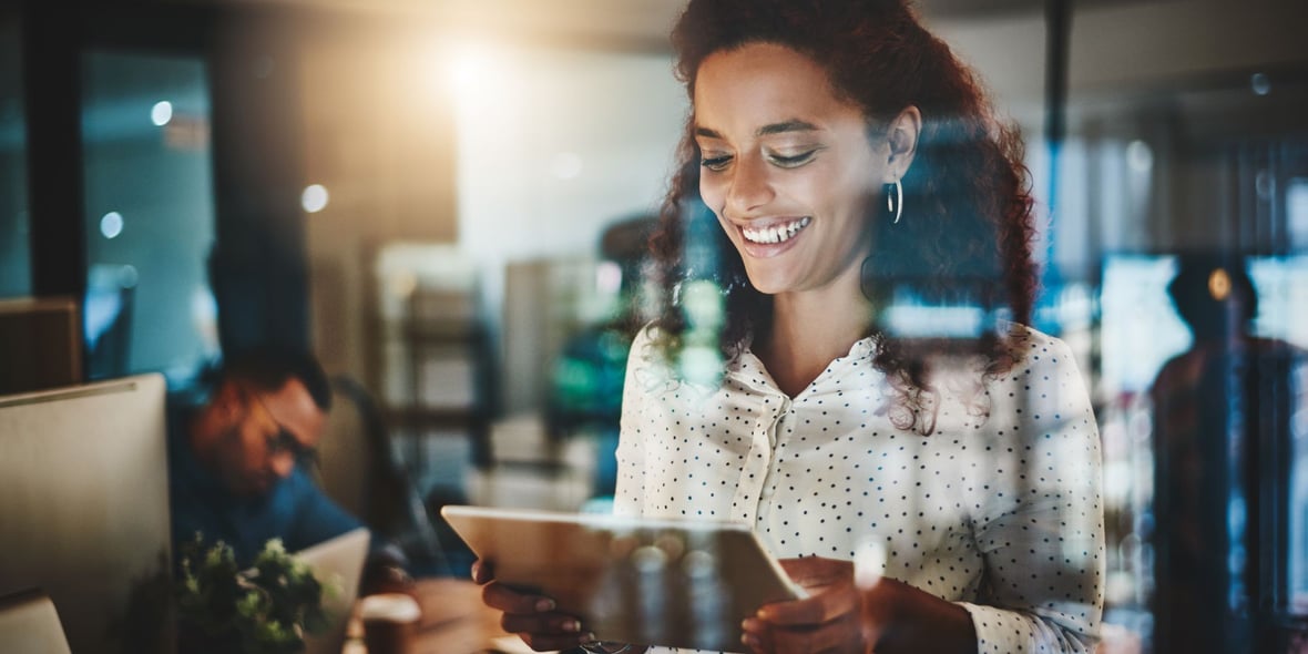 Woman looking at a tablet and smiling