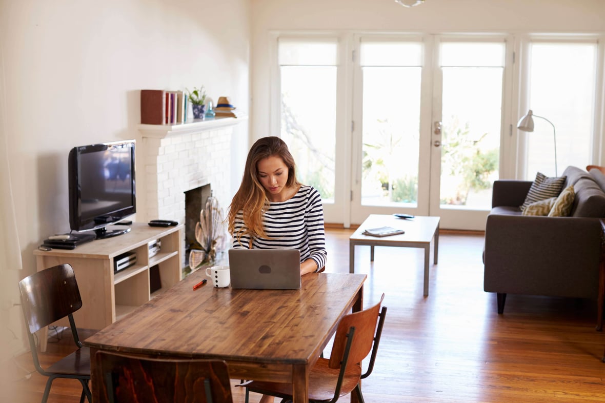 Woman working remotely at her dining room table