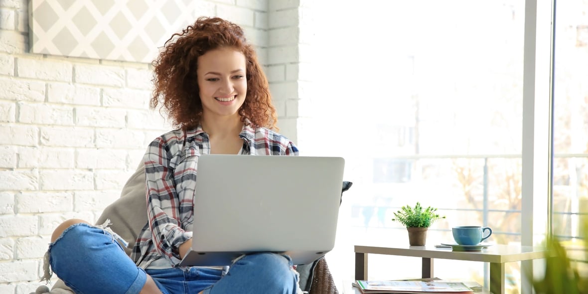 A woman smiles as she navigates a website because it provides a great user experience.