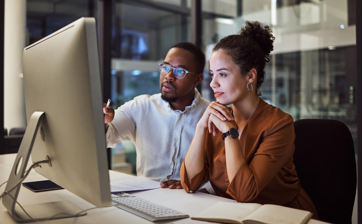 Man and woman working on computer to improve email deliverability