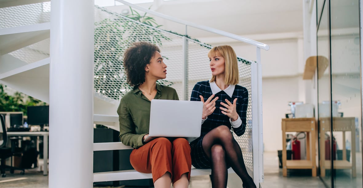 Two marketing professionals discussing in front of a computer