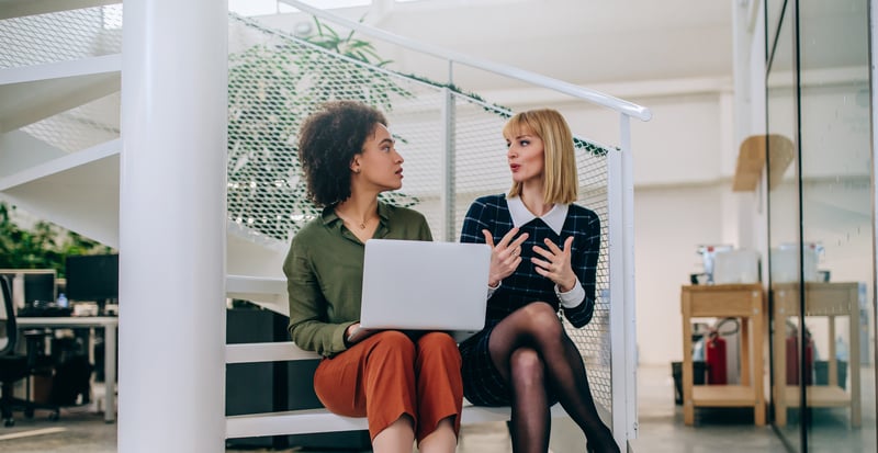 Two marketing professionals discussing in front of a computer