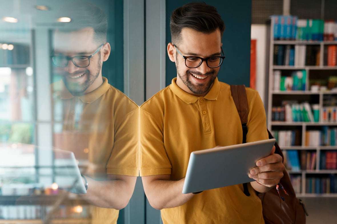 higher education student reading university institution content on a tablet in a modern office