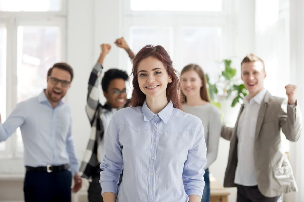 Four team members in the background celebrating their female coworker for personalizing her sales process.