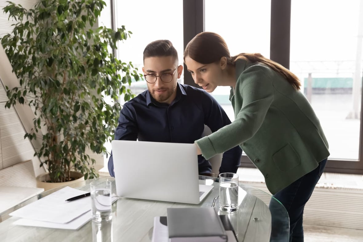 Coworkers looking at a laptop computer with a top intent data providers list on it.