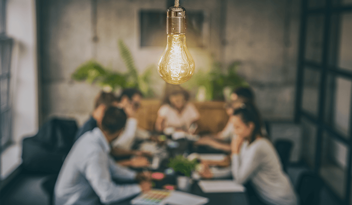 glowing light bulb above brainstorming team