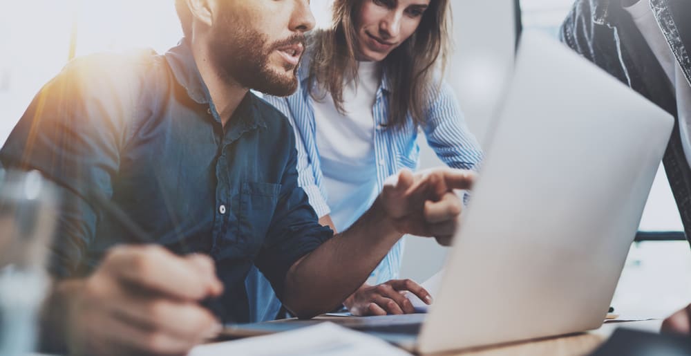 Two people looking at a Screaming Frog Crawl on a laptop computer