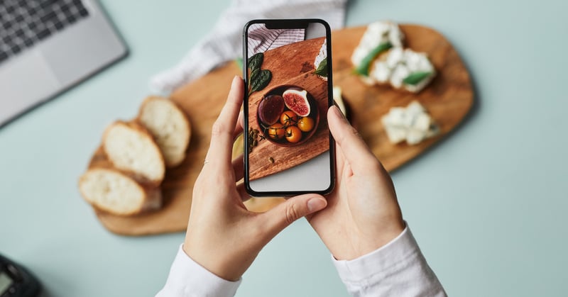 Top view of person taking aesthetic photo of food for promotion