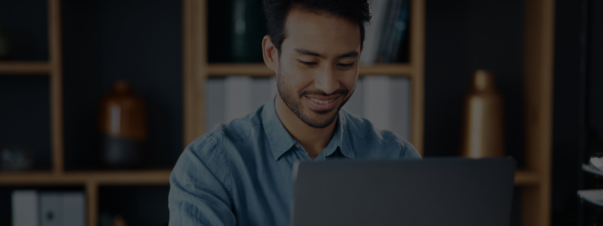 Man smiling at his laptop