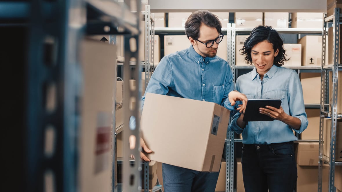 Man and woman looking at a a tablet screen in a warehouse setting