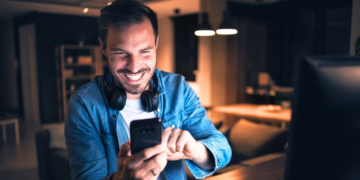 A man smiling at his phone