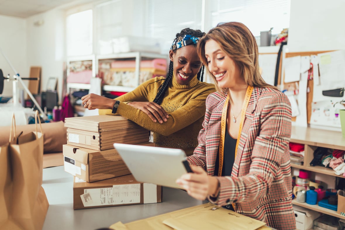 Two women looking at an iPad on their store