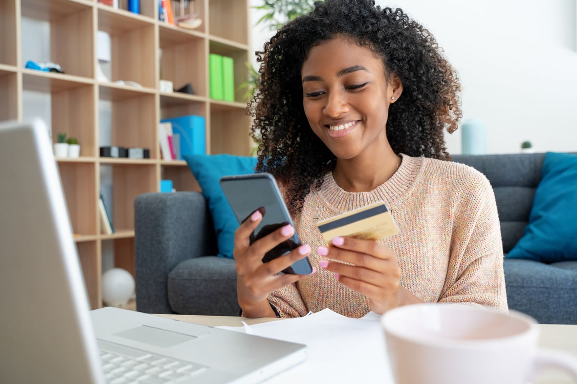 Woman shopping online looking at her phone and credit card