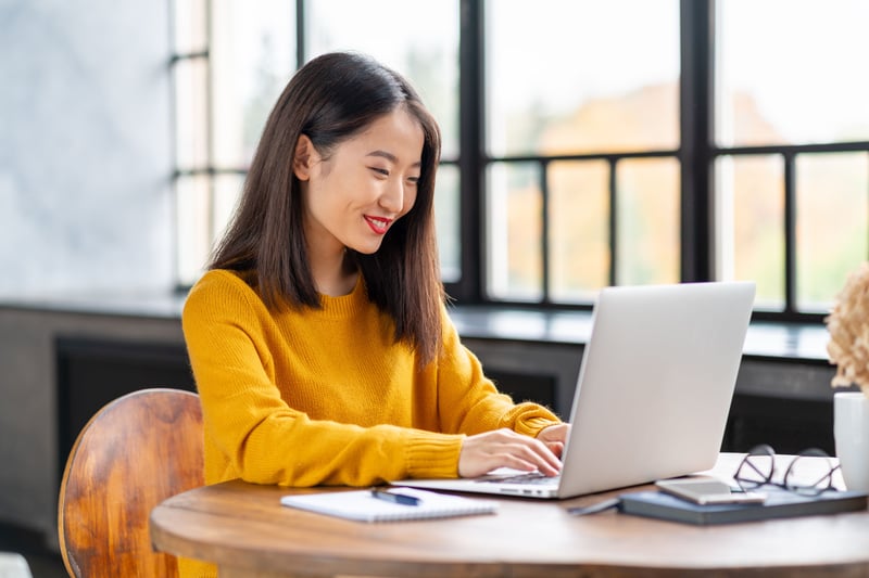 A marketer looking at her laptop while smiling