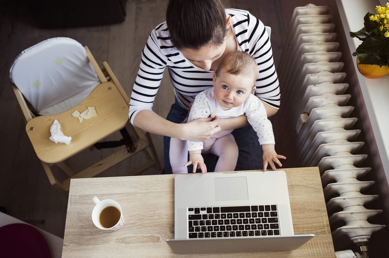 mom holding baby with laptop and coffee
