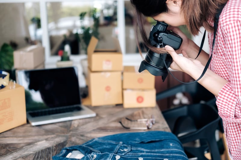 A woman photographing a shirt with her camera