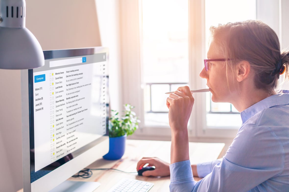 Woman looking at a list of emails in her desktop computer