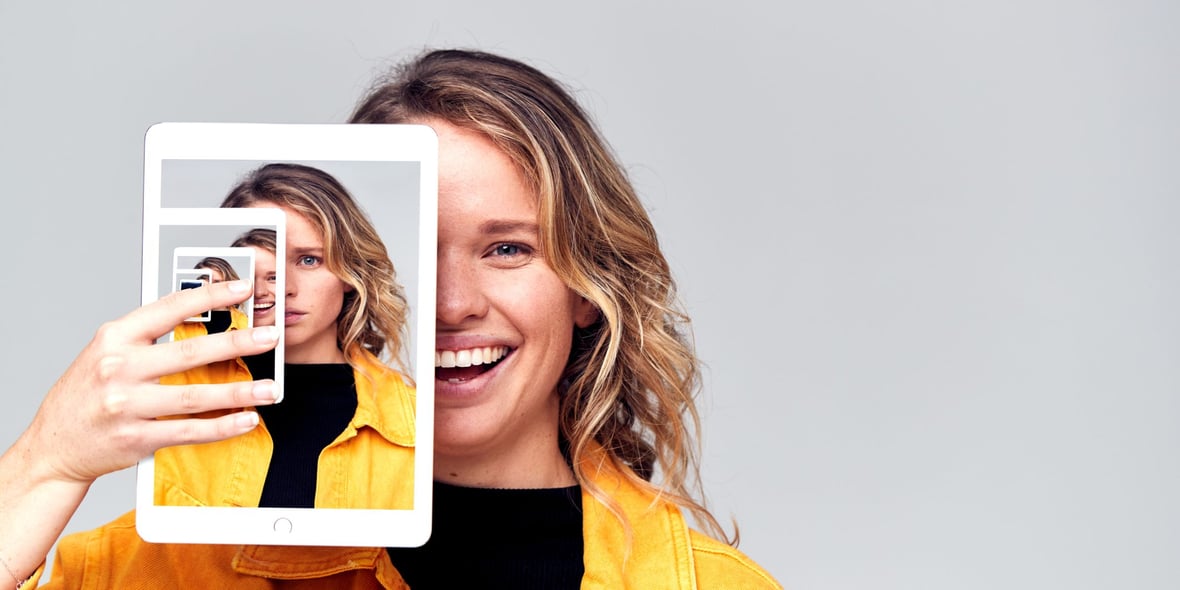 Woman smiling in front of a tablet