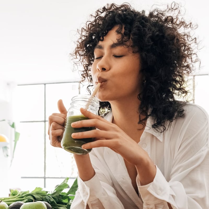woman drinking a green smoothie