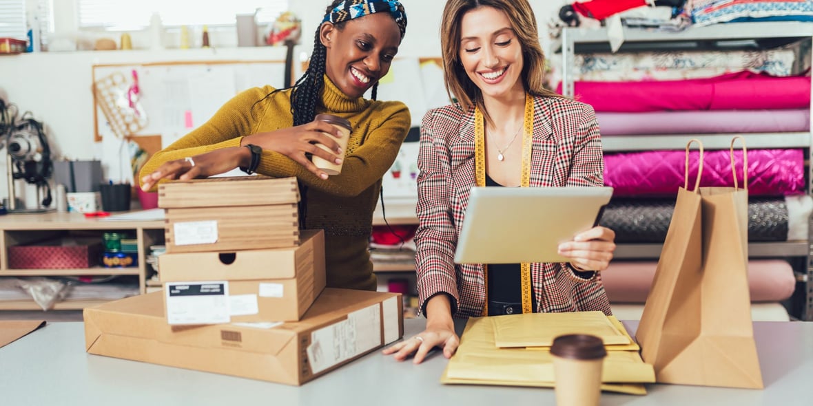 Two women smiling while looking at a tablet