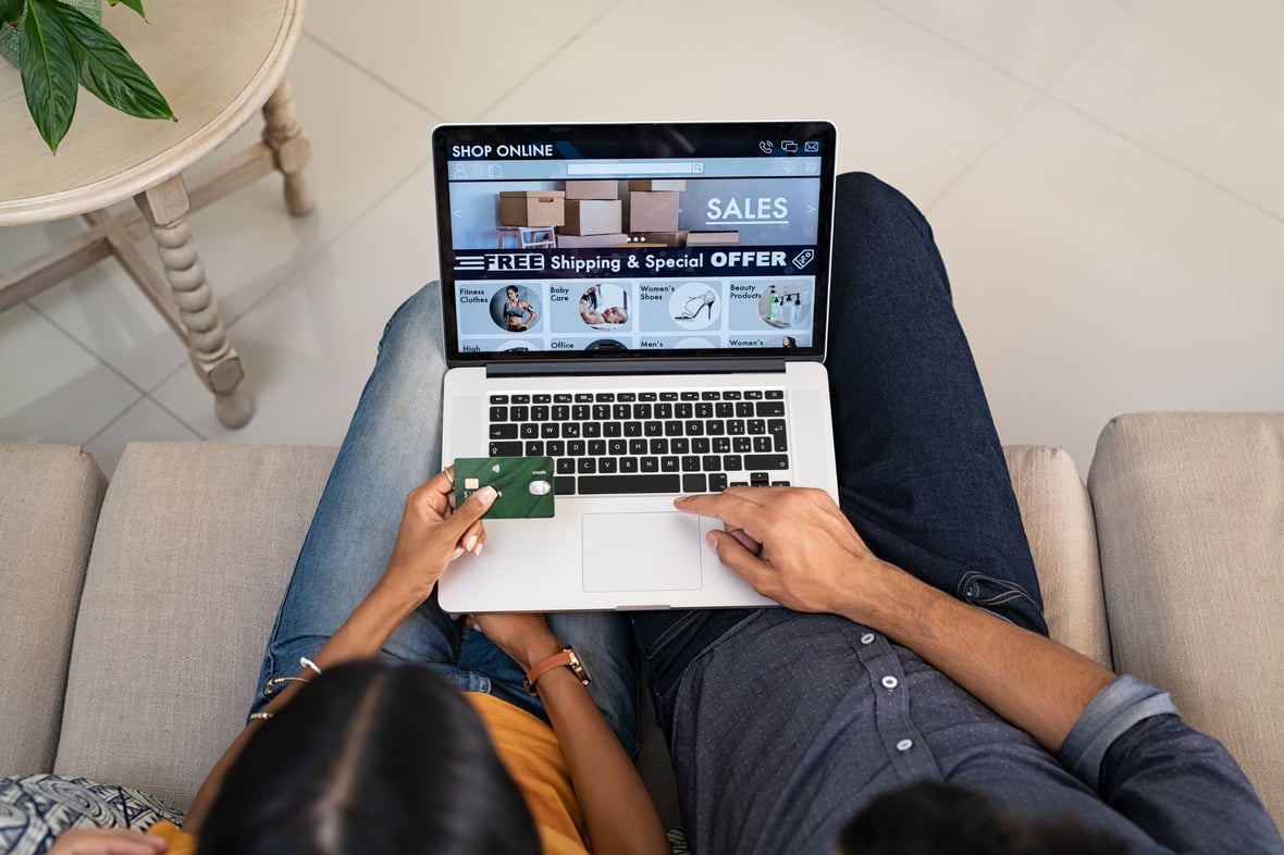 Two people browsing online while holding a credit card