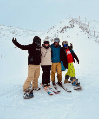 Four SmartBugs standing together on snowboards and skis